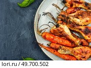 Roasted chicken drumsticks fried with vegetables. Copy space. Baked chicken drumstick, top view. Стоковое фото, агентство Ingram Publishing / Фотобанк Лори