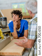 Young carpenter really doesn't look interested. Стоковое фото, агентство Ingram Publishing / Фотобанк Лори