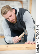 carpenter hammers a nail into a plank. Стоковое фото, агентство Ingram Publishing / Фотобанк Лори