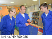 Tutor holding equipment and talking to apprentice. Стоковое фото, агентство Ingram Publishing / Фотобанк Лори
