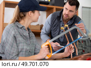 tradeswoman cutting copper pipe with hacksaw. Стоковое фото, агентство Ingram Publishing / Фотобанк Лори