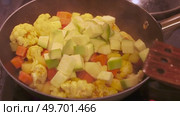 Stir fry with fresh cauliflower, carrots, and potatoes in a black pan. Стоковое видео, видеограф Татьяна Лобанова / Фотобанк Лори