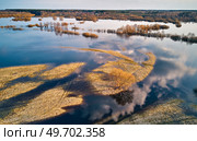 Spring flood rural landscape. Trees, meadow, bushes, fields, country road under High Water inundation. Sky, clouds reflection in evening light. Freshet Overflow aerial view. Floodplain area. Belarus. Стоковое фото, агентство Ingram Publishing / Фотобанк Лори