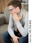 man sat on the sofa massaging a sore tooth. Стоковое фото, агентство Ingram Publishing / Фотобанк Лори