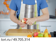 a man pealing apple with knife. Стоковое фото, агентство Ingram Publishing / Фотобанк Лори