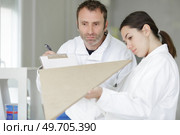 teacher assessing student with wooden template. Стоковое фото, агентство Ingram Publishing / Фотобанк Лори