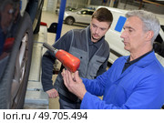 auto mechanic teacher and trainee performing tests at mechanic school. Стоковое фото, агентство Ingram Publishing / Фотобанк Лори