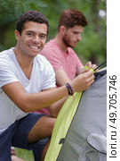 men setting up a tent in the forest camp. Стоковое фото, агентство Ingram Publishing / Фотобанк Лори
