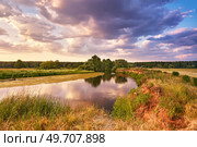 Landscape with sunset over river. Evening with Dramatic beautiful clouds on sky. Water reflection. Trees on riverbank. Weather change. Green filed and meadow. Europe, Belarus. Стоковое фото, агентство Ingram Publishing / Фотобанк Лори