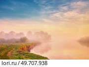 Landscape with sunrise over river. Morning beautiful clouds on sky. Water reflection scene. Rural dirt road on riverbank. Calm foggy weather. Green filed and meadow. Europe, Belarus. Стоковое фото, агентство Ingram Publishing / Фотобанк Лори