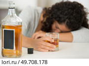woman holding glass of whisky slumped over table. Стоковое фото, агентство Ingram Publishing / Фотобанк Лори