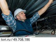 electrical worker wiring in ceiling. Стоковое фото, агентство Ingram Publishing / Фотобанк Лори