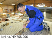 a man is disassembling a boat. Стоковое фото, агентство Ingram Publishing / Фотобанк Лори