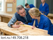 carpentry teacher instructing female student. Стоковое фото, агентство Ingram Publishing / Фотобанк Лори