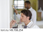 painter using a brush to finish a white wall. Стоковое фото, агентство Ingram Publishing / Фотобанк Лори