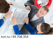 apprentices looking at a portable humidifier unit. Стоковое фото, агентство Ingram Publishing / Фотобанк Лори