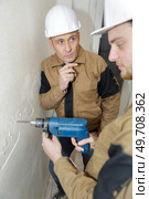young man drilling the wall with drill perforator. Стоковое фото, агентство Ingram Publishing / Фотобанк Лори