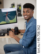 young man holding digital single-lens reflex camera dslr checking camera. Стоковое фото, агентство Ingram Publishing / Фотобанк Лори