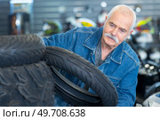 senior man looking at motorcycle tyres. Стоковое фото, агентство Ingram Publishing / Фотобанк Лори