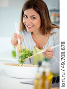cheerful woman tossing a salad. Стоковое фото, агентство Ingram Publishing / Фотобанк Лори