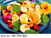 Vegetarian summer salad of fresh fruits and nasturtium leaves. Close up.. Fruit salad with nasturtium. Стоковое фото, агентство Ingram Publishing / Фотобанк Лори