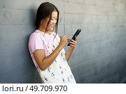 Happy Young Chinese woman using her smartphone with a pen or stylus, outdoors Asian female wearing casual clothes.. Happy Young Chinese woman using her smartphone with a pen or stylus, outdoors. Стоковое фото, агентство Ingram Publishing / Фотобанк Лори