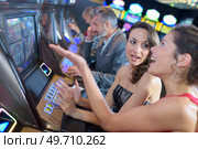 beautiful women in dress playing slot machine. Стоковое фото, агентство Ingram Publishing / Фотобанк Лори