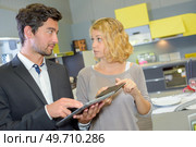 Woman showing man the colour tile she wants. Стоковое фото, агентство Ingram Publishing / Фотобанк Лори