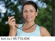 female coach timing runner in a park. Стоковое фото, агентство Ingram Publishing / Фотобанк Лори