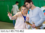 young female archer teaching a new member. Стоковое фото, агентство Ingram Publishing / Фотобанк Лори