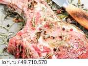 Raw pork steak Tomahawk marinated in spicy herbs. Preparation dinner.. Raw pork uncooked steak Tomahawk. Стоковое фото, агентство Ingram Publishing / Фотобанк Лори