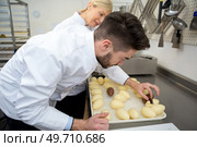 young confectioner decorating choloate egg. Стоковое фото, агентство Ingram Publishing / Фотобанк Лори