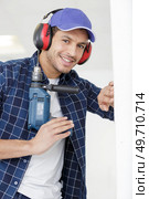 smily man drills a wall with a drill. Стоковое фото, агентство Ingram Publishing / Фотобанк Лори