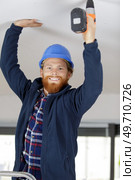 happy construction worker assembles ceili. Стоковое фото, агентство Ingram Publishing / Фотобанк Лори