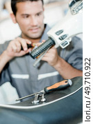Mechanic repairing a throttle twist grip. Стоковое фото, агентство Ingram Publishing / Фотобанк Лори