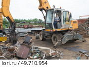 magnetic crane loading scrap metals at junkyard. Стоковое фото, агентство Ingram Publishing / Фотобанк Лори