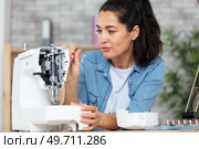 woman repairing dismantled sewing machine. Стоковое фото, агентство Ingram Publishing / Фотобанк Лори
