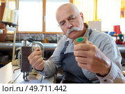 senior man threading old fashioned manual sewing machine. Стоковое фото, агентство Ingram Publishing / Фотобанк Лори