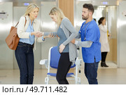 doctor helping pregnant woman to sit down on wheelchair. Стоковое фото, агентство Ingram Publishing / Фотобанк Лори