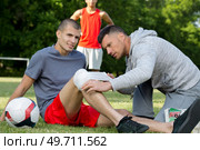 trainer bandaging athletes knee injury. Стоковое фото, агентство Ingram Publishing / Фотобанк Лори