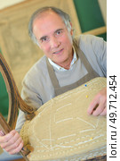 man trying to fix a chair. Стоковое фото, агентство Ingram Publishing / Фотобанк Лори