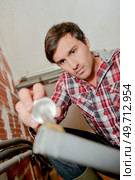 a plumber gluing a pipe. Стоковое фото, агентство Ingram Publishing / Фотобанк Лори