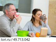 senior man and young woman eating lunch in workplace. Стоковое фото, агентство Ingram Publishing / Фотобанк Лори