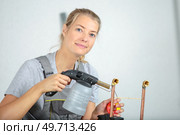 female jeweller blowing a torch. Стоковое фото, агентство Ingram Publishing / Фотобанк Лори