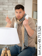 man holding incandescent and led lamps two different light bulbs. Стоковое фото, агентство Ingram Publishing / Фотобанк Лори