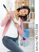 happy woman cleaning home singing and having fun. Стоковое фото, агентство Ingram Publishing / Фотобанк Лори
