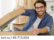 contented man opening a cardboard box. Стоковое фото, агентство Ingram Publishing / Фотобанк Лори