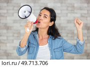 beautiful woman excited and euphoric shouting with a megaphone. Стоковое фото, агентство Ingram Publishing / Фотобанк Лори