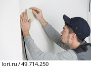 handsome young man electrician installing air conditioning in client house. Стоковое фото, агентство Ingram Publishing / Фотобанк Лори