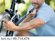 a man pumping bicycle wheel. Стоковое фото, агентство Ingram Publishing / Фотобанк Лори